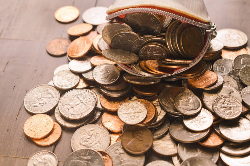 American coins spilling out of a coin purse on a table