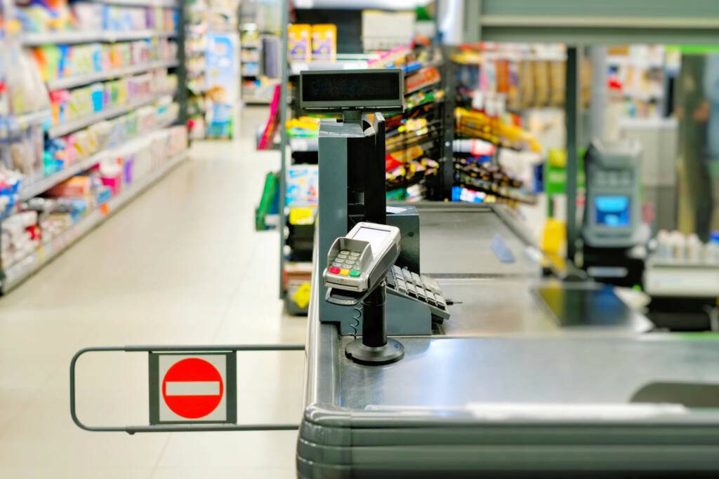 Convenience store or grocery store cash register with aisle of product in background