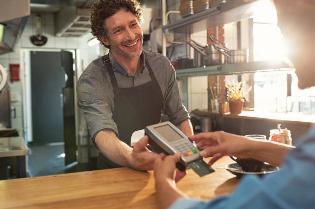 business owner receiving electronic payment on handheld credit card machine.