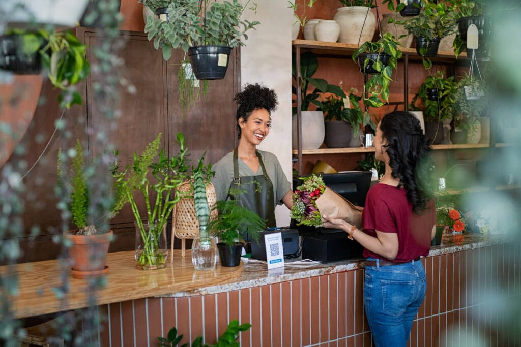 Two people talking in a plant store at the counter