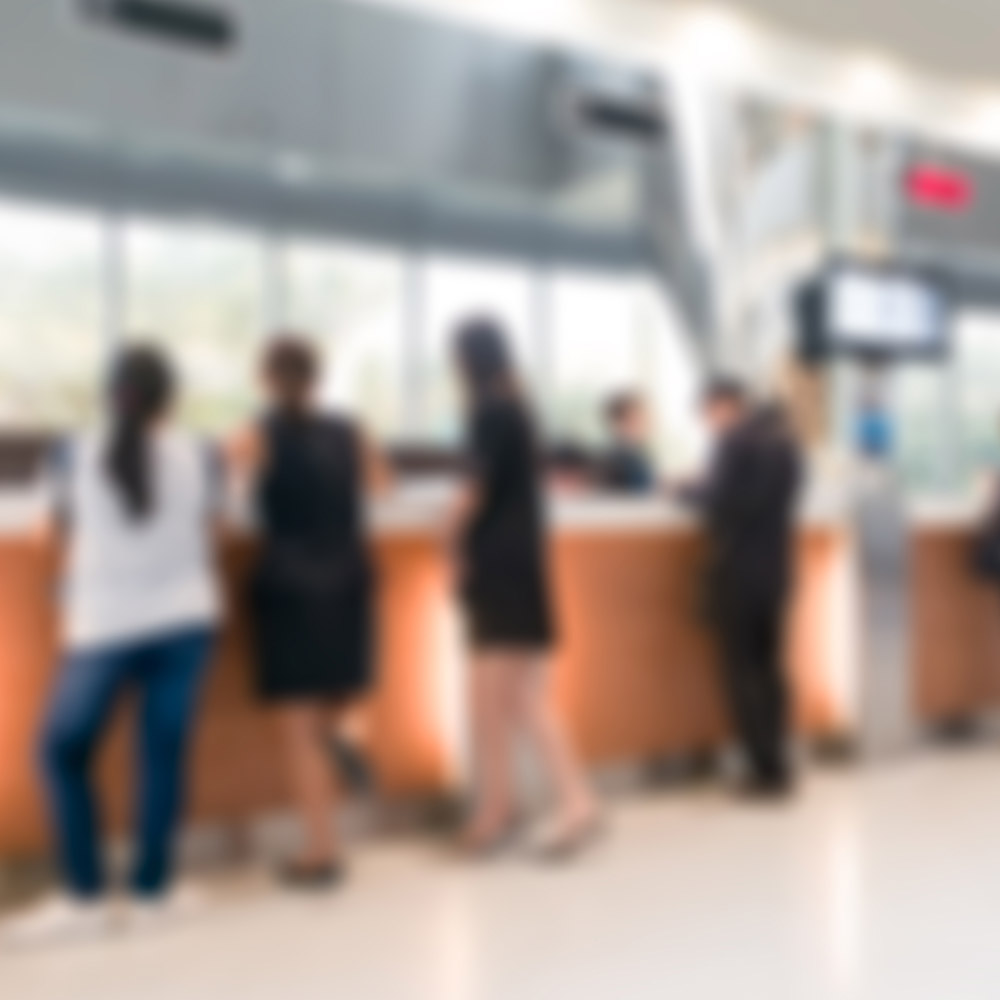 Blurry photo of people standing at the counter of a bank