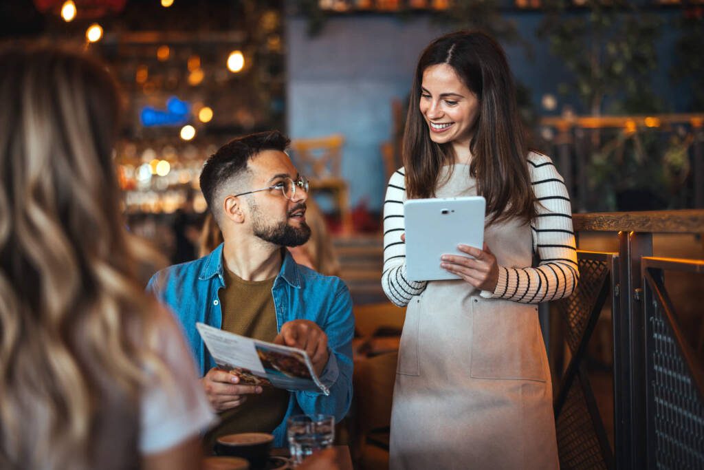 a restaurant server telling a customer about a menu's pricing